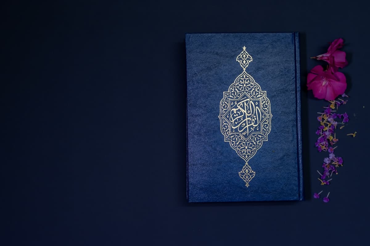 Saint Coran avec calligraphie dorée et fleurs représentant la charité islamique