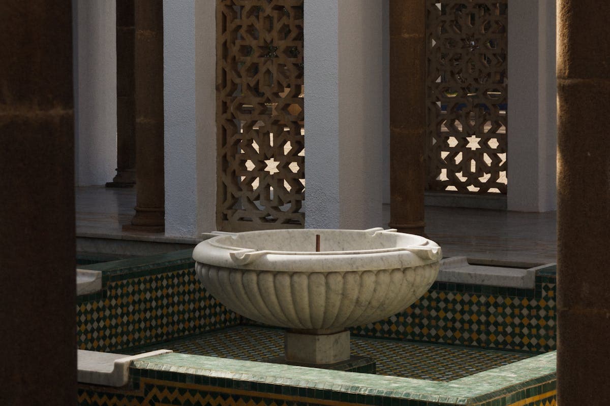 Ornate Moroccan courtyard with traditional fountain and zellige tilework, characteristic of zawiya architecture