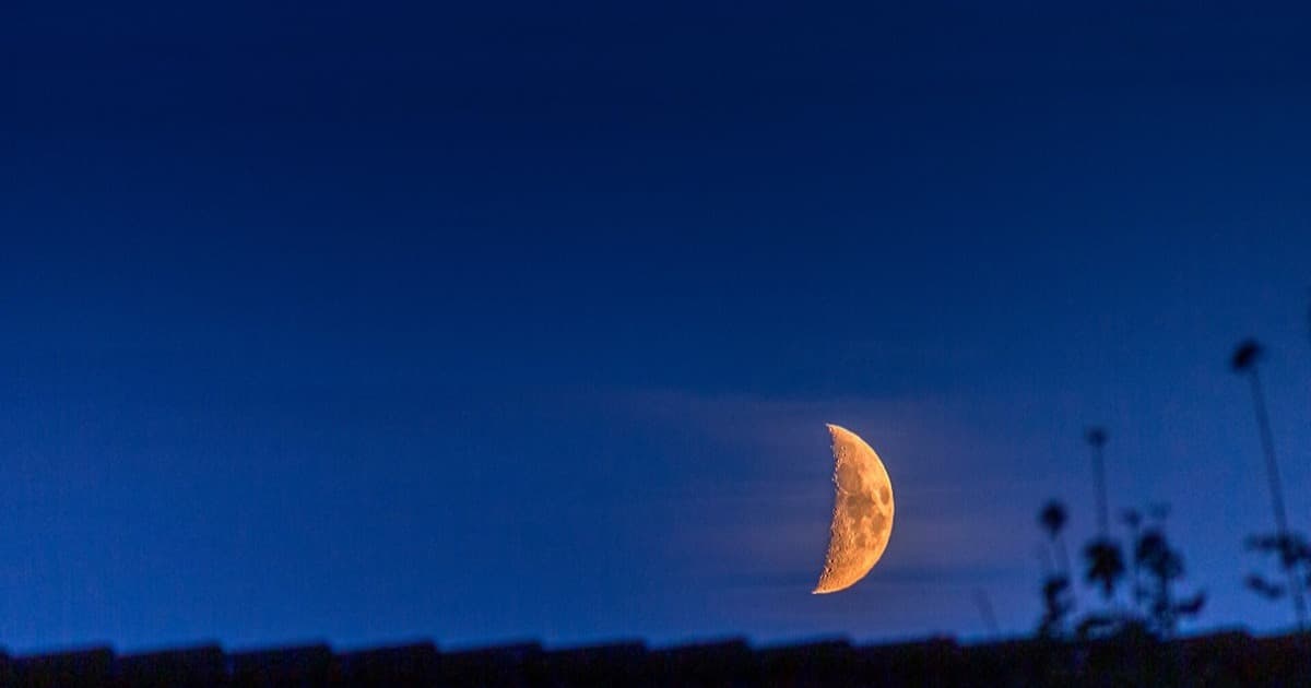 Fin croissant de lune cireuse se couchant à l'horizon au crépuscule, le hilal observé au Maroc pour confirmer le début de Safar